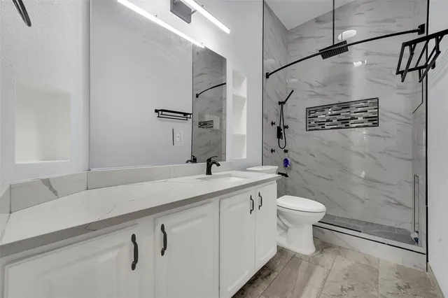 a bathroom with a sink a toilet and shower