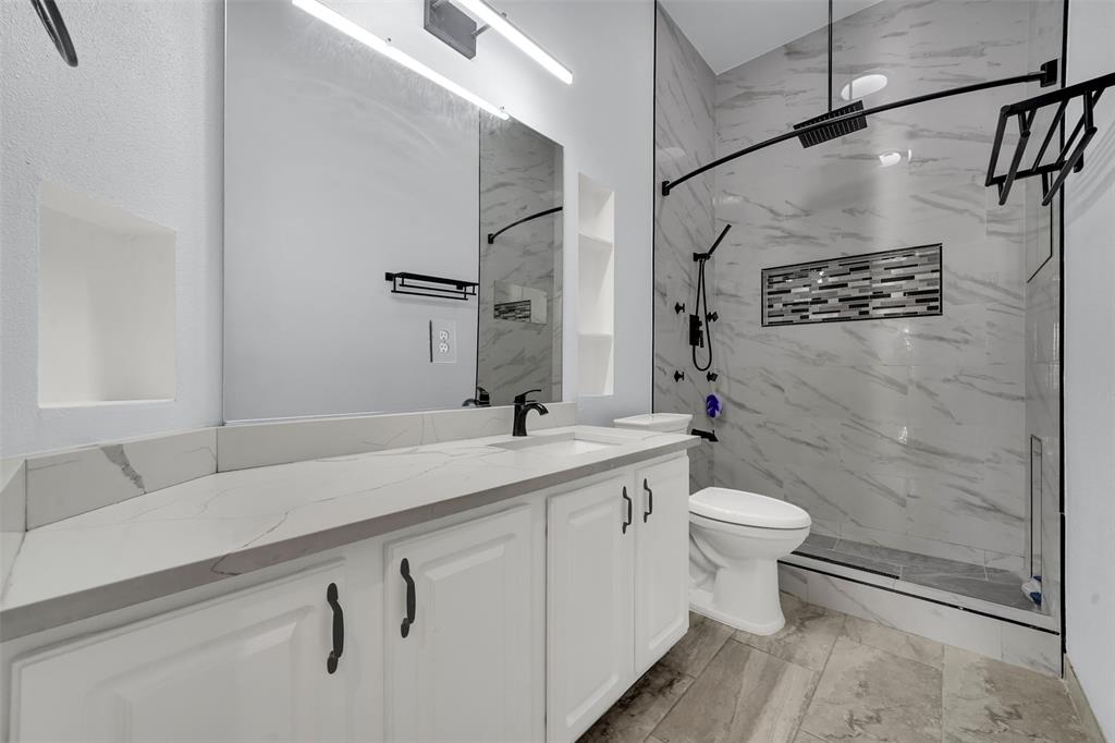 5409 Deer Brook Road Garland, TX 75044 - Photo 23 of 31 a bathroom with a sink a toilet and shower