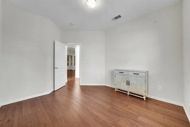 an empty room with wooden floor and white walls