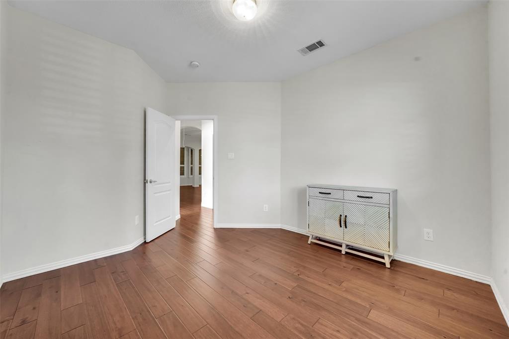 5409 Deer Brook Road Garland, TX 75044 - Photo 25 of 31 an empty room with wooden floor and white walls