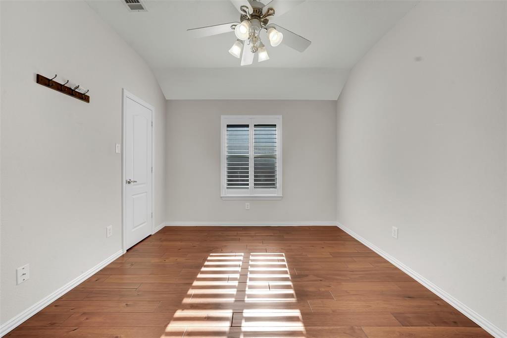 5409 Deer Brook Road Garland, TX 75044 - Photo 26 of 31 a view of a room with wooden floor a ceiling fan and windows
