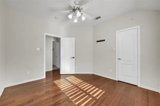 a view of a room with wooden floor and a ceiling fan