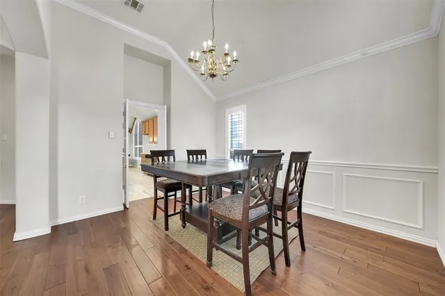 a dining room with furniture wooden floor and a chandelier