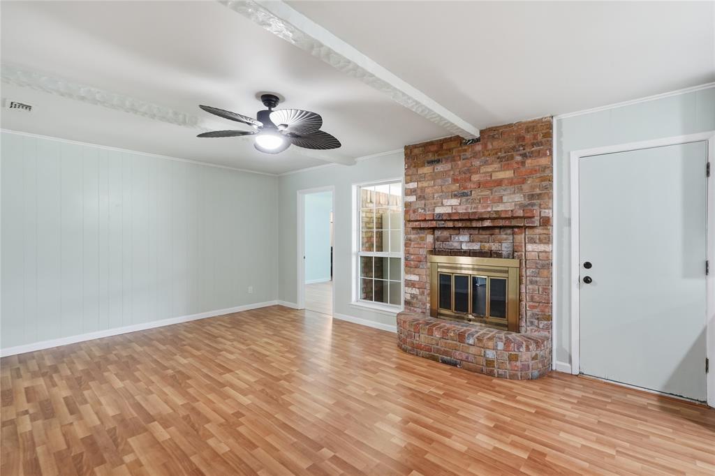 837 Springdale Road Bedford, TX 76021 - Photo 7 of 28 Brick fireplace with a brass-trimmed insert and hearth