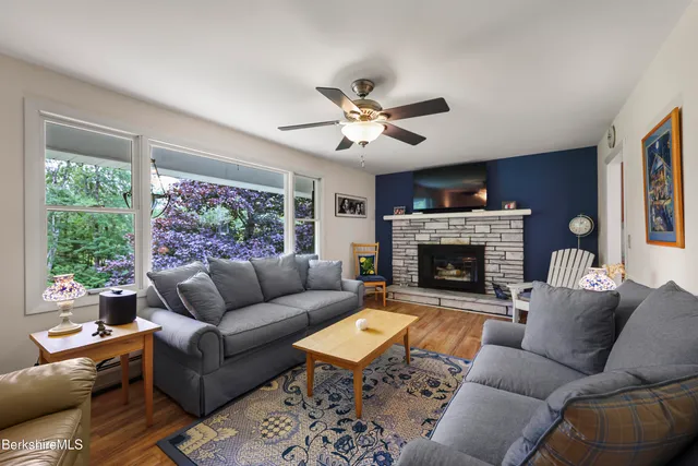 a kitchen with stainless steel appliances granite countertop a refrigerator oven a sink dishwasher and white cabinets with wooden floor