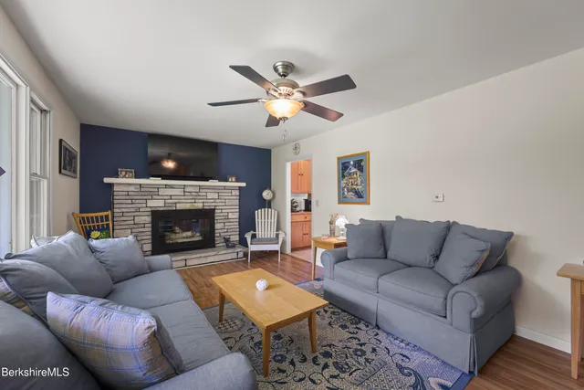 a living room with furniture kitchen view and a potted plant