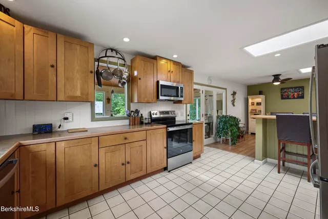 a kitchen with stainless steel appliances granite countertop a stove top oven a sink dishwasher and a microwave oven on the blue kitchen countertops