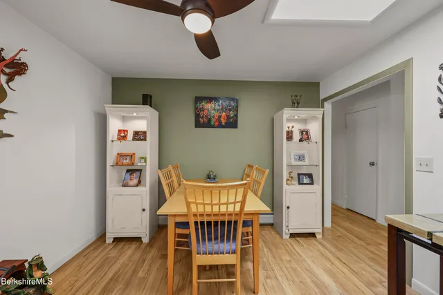 a dining area with stainless steel appliances kitchen island granite countertop a dining table chairs and a oven