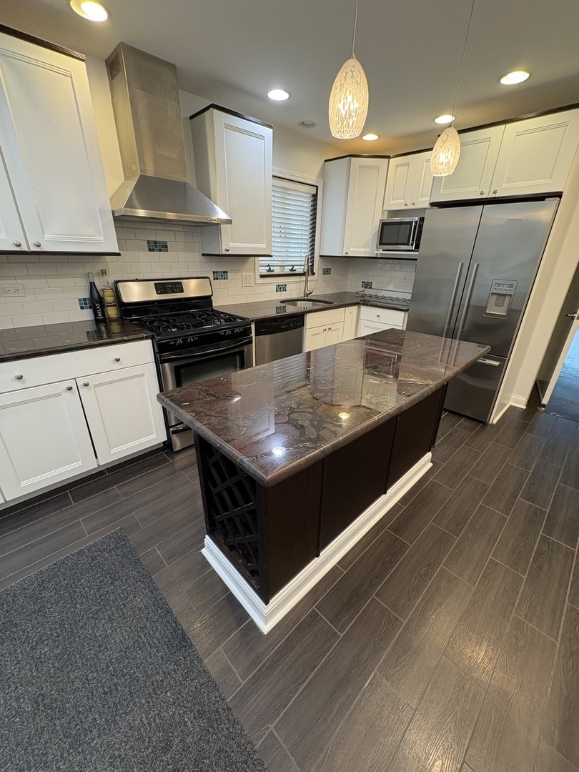 3528 North Neva Avenue Chicago, IL 60634 - Photo 11 of 37 a kitchen with stainless steel appliances granite countertop a sink a stove and a refrigerator