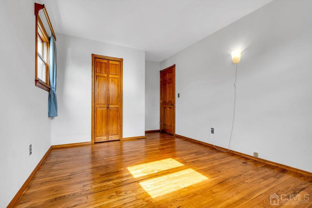13 Eardley Road Edison, NJ 08817 - Photo 12 of 35 a view of an empty room with wooden floor and a window