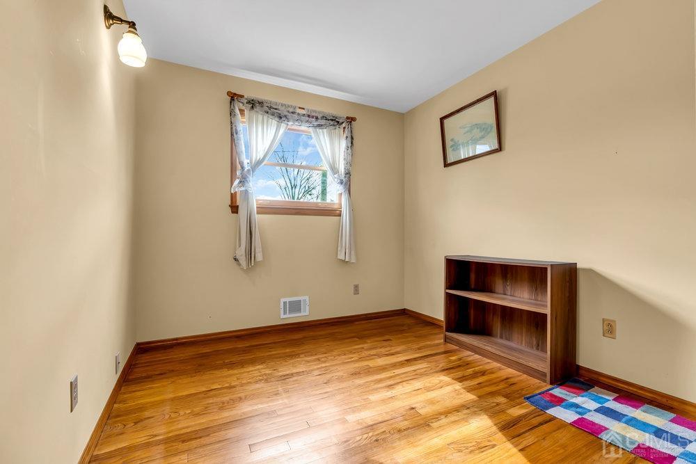 13 Eardley Road Edison, NJ 08817 - Photo 16 of 35 a view of an empty room with a window and wooden floor