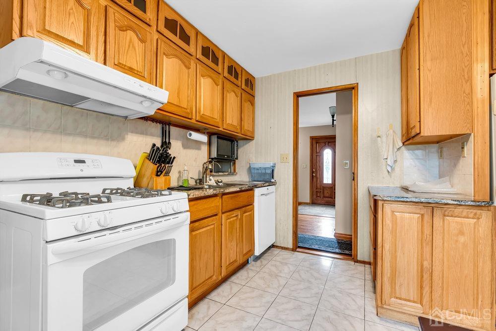 13 Eardley Road Edison, NJ 08817 - Photo 7 of 35 a kitchen with a stove top oven cabinets and a refrigerator
