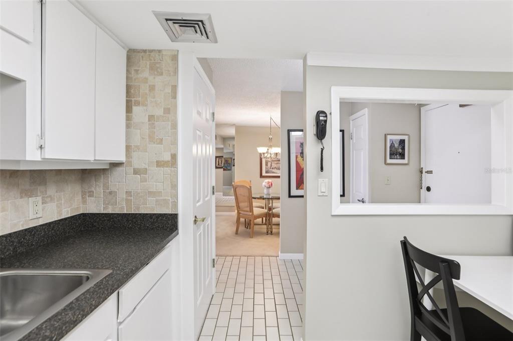 1 Key Capri, Unit 302E Treasure Island, FL 33706 - Photo 11 of 29 a hallway with a sink and cabinets