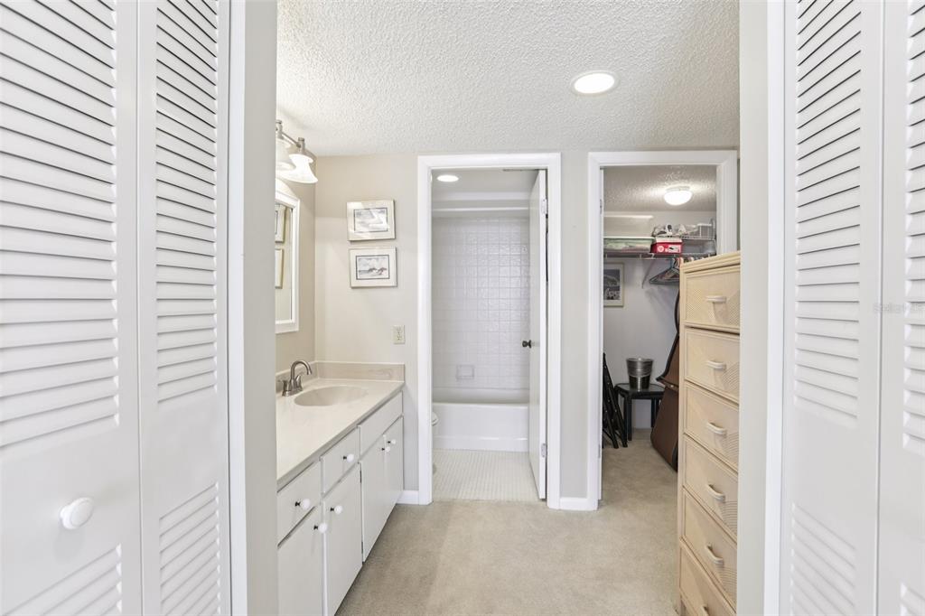 1 Key Capri, Unit 302E Treasure Island, FL 33706 - Photo 15 of 29 a bathroom with a granite countertop sink mirror and shower