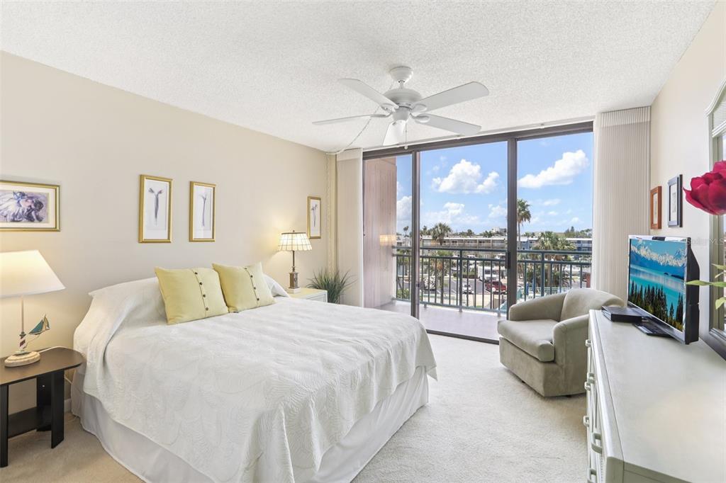 1 Key Capri, Unit 302E Treasure Island, FL 33706 - Photo 19 of 29 a bedroom with a balcony a bed and a large window