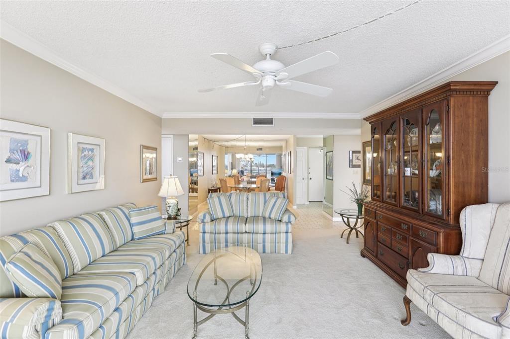 1 Key Capri, Unit 302E Treasure Island, FL 33706 - Photo 3 of 29 a living room with furniture and a chandelier
