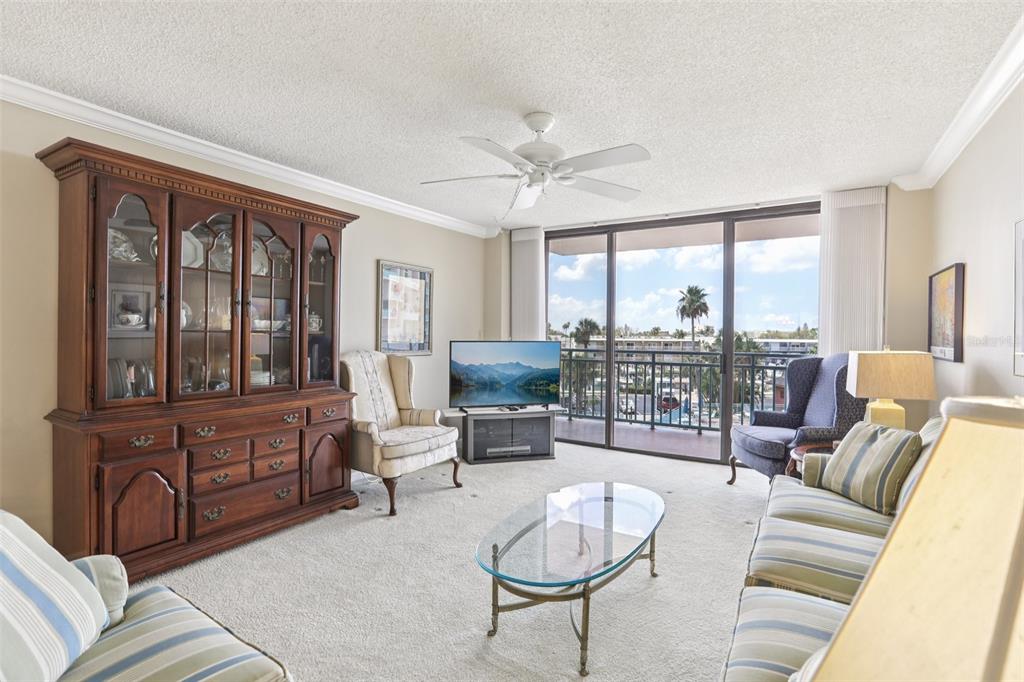1 Key Capri, Unit 302E Treasure Island, FL 33706 - Photo 4 of 29 a living room with furniture large windows and wooden floor