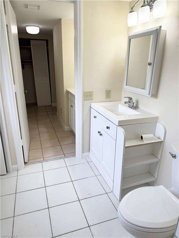 124 Cypress Way East, Unit E3 Naples, FL 34110 - Photo 7 of 22 a bathroom with a sink a toilet a mirror and vanity