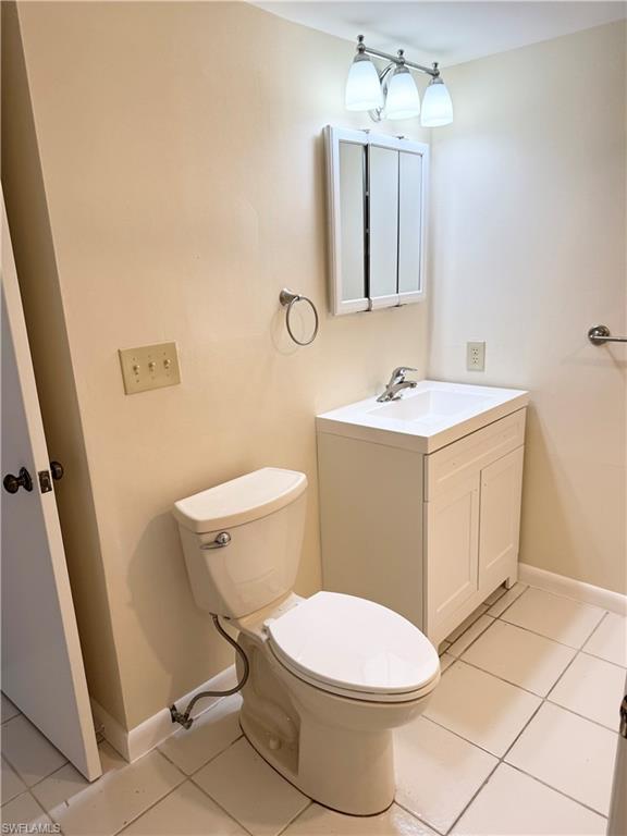 124 Cypress Way East, Unit E3 Naples, FL 34110 - Photo 9 of 22 a white toilet sitting next to a bathroom sink