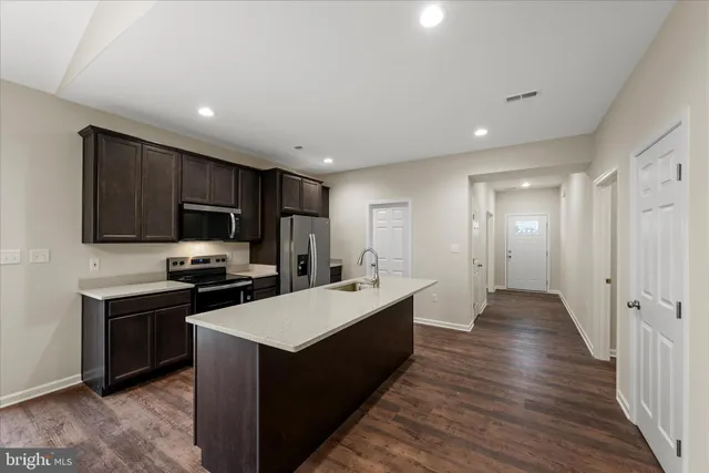 a large kitchen with stainless steel appliances lots of counter space and wooden floor