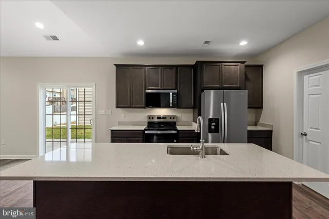 a kitchen with kitchen island a sink appliances and cabinets