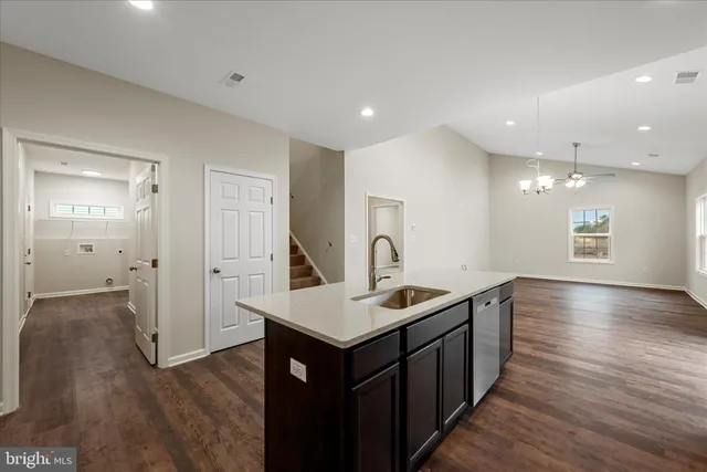 a kitchen with a sink cabinets and wooden floor