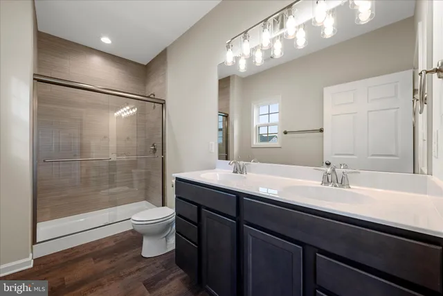 a bathroom with a double vanity sink toilet and shower