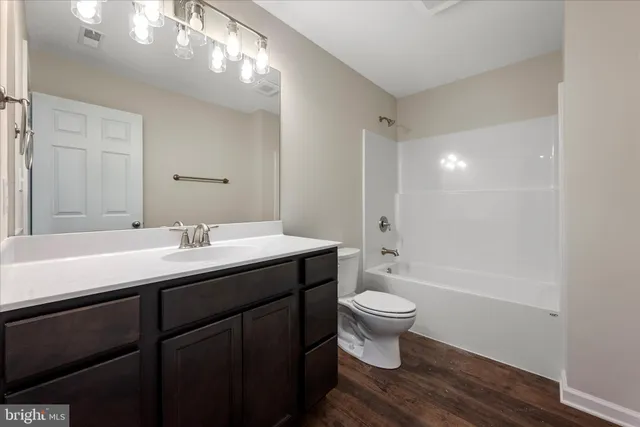 a bathroom with a sink a toilet a large mirror and shower