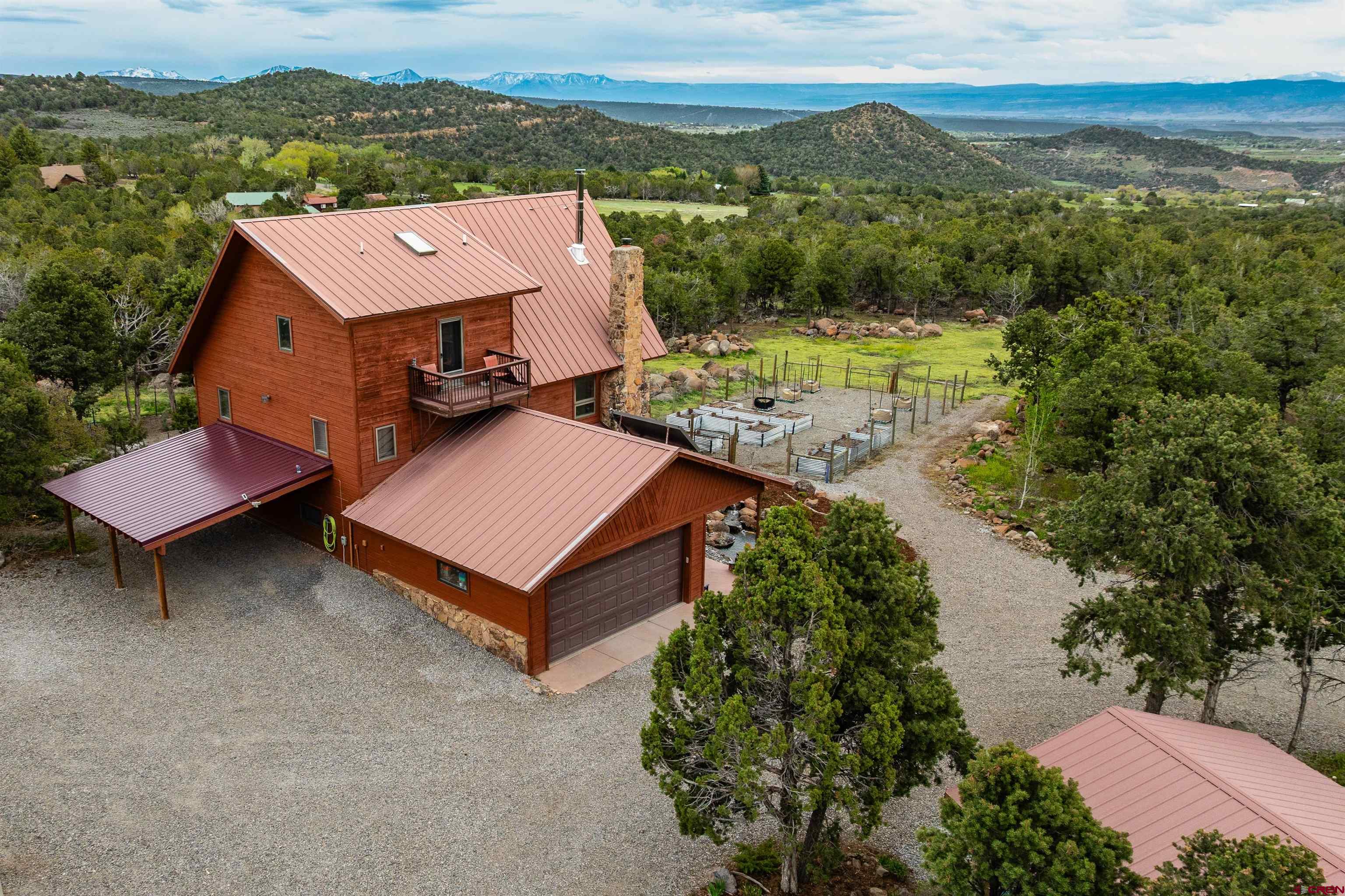 21186 Uintah Road Cedaredge, CO 81413 - Photo 39 of 45 an aerial view of a house with a garden and lake view
