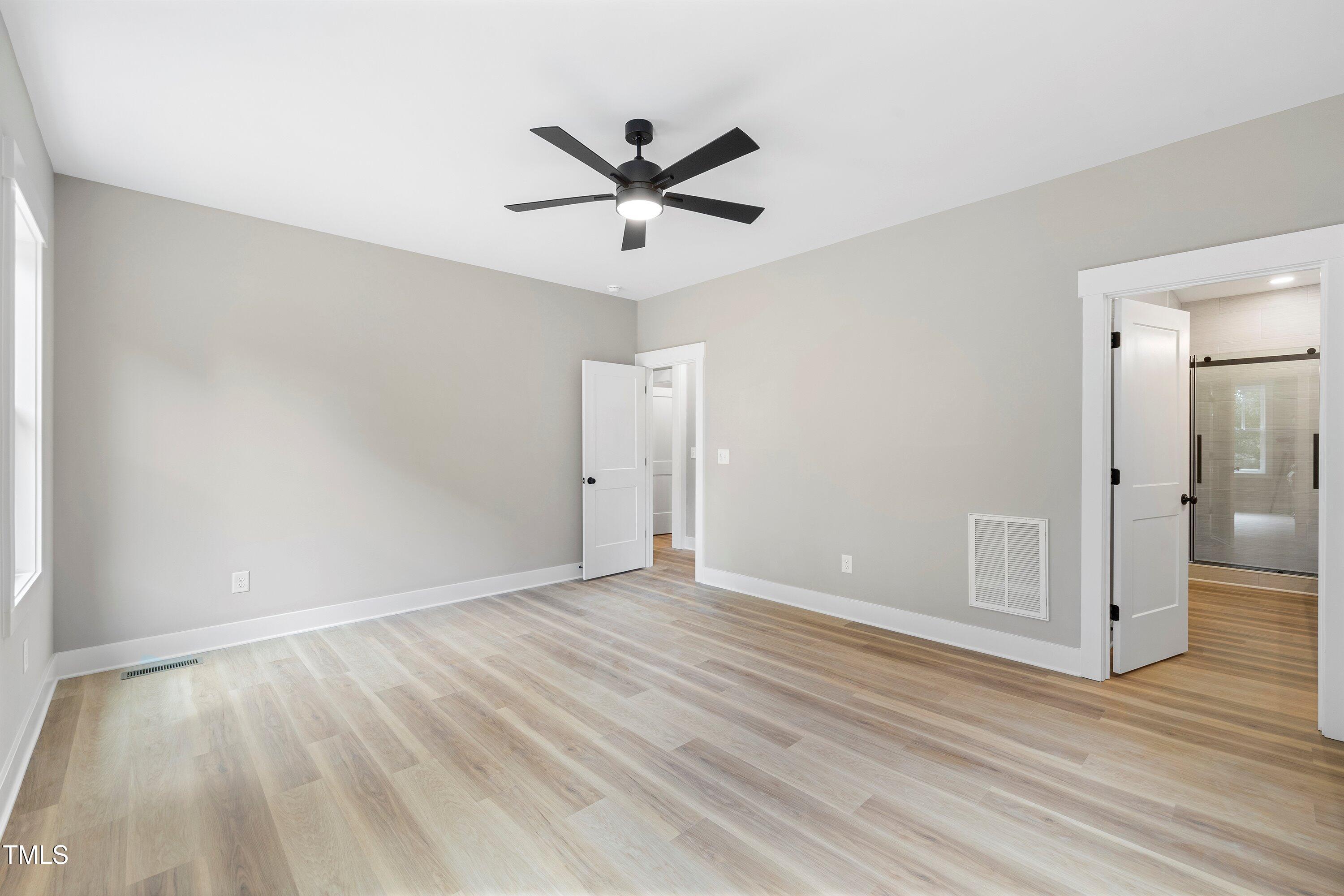 9293 Bear Run Lane Middlesex, NC 27557 - Photo 16 of 36 an empty room with wooden floor a ceiling fan and windows