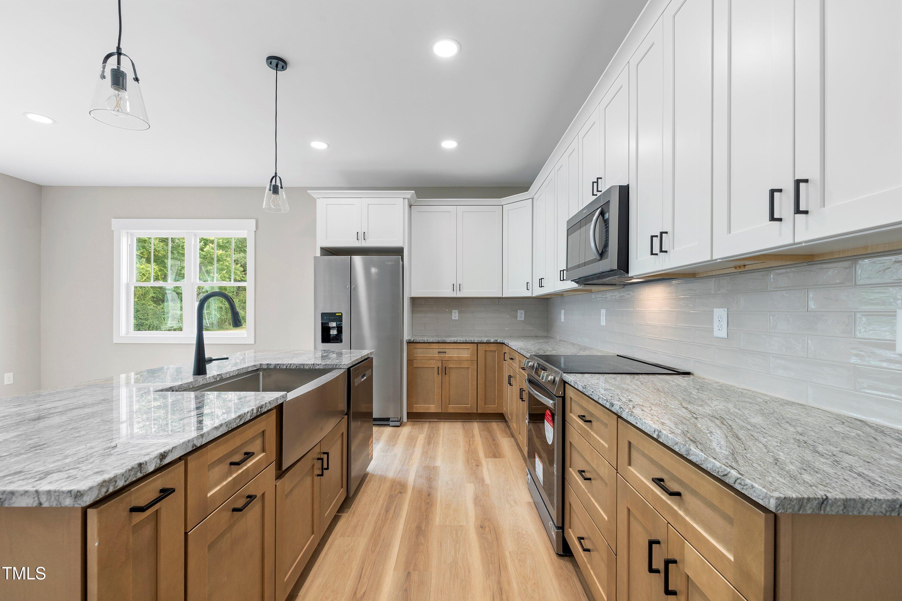 9293 Bear Run Lane Middlesex, NC 27557 - Photo 8 of 36 a large kitchen with granite countertop a sink counter space stainless steel appliances and cabinets