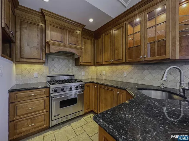 a kitchen with stainless steel appliances granite countertop a stove and a sink