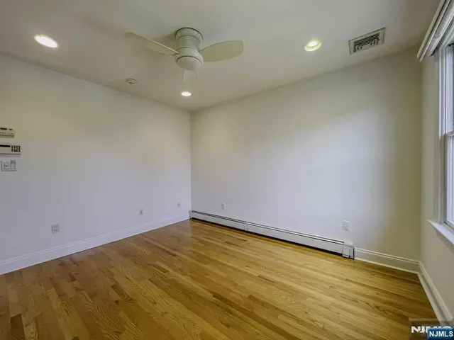 a view of a yard with plants and large tree