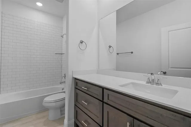 a bathroom with a granite countertop sink a toilet and shower