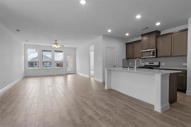 a open kitchen with kitchen island a sink dishwasher a refrigerator and a stove with wooden floor