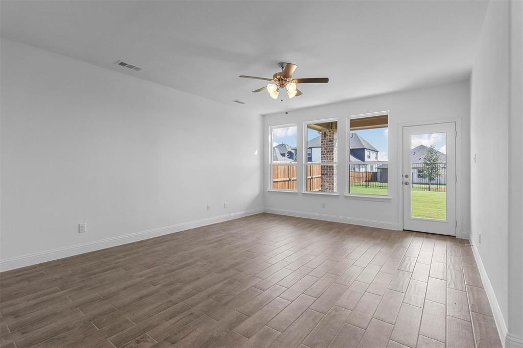 704 Amenduni Lane Anna, TX 75409 - Photo 5 of 19 wooden floor in an empty room with a window