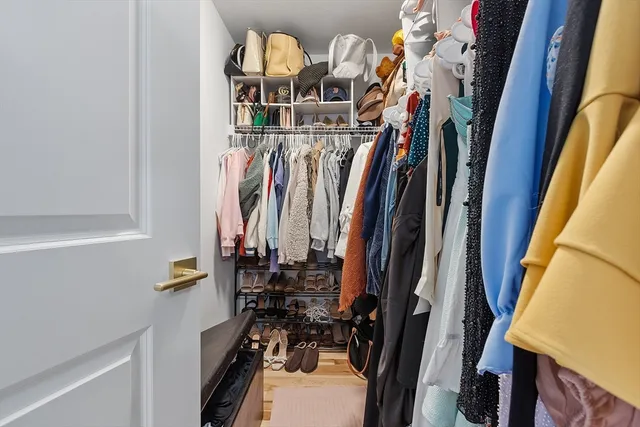 a view of walk in closet with clothes