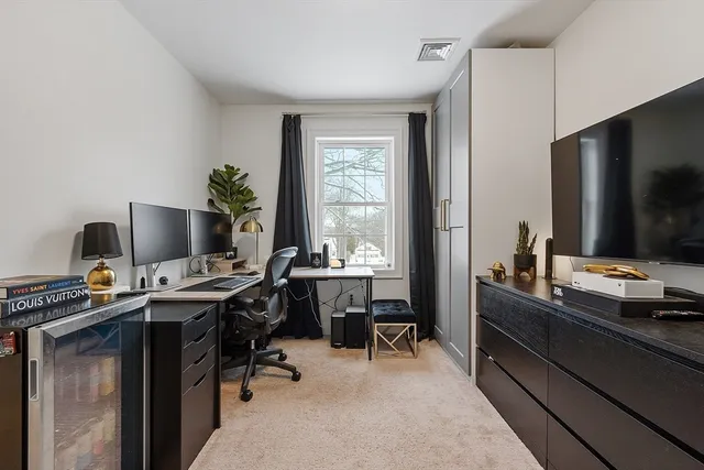 a view of a workspace with furniture and a window