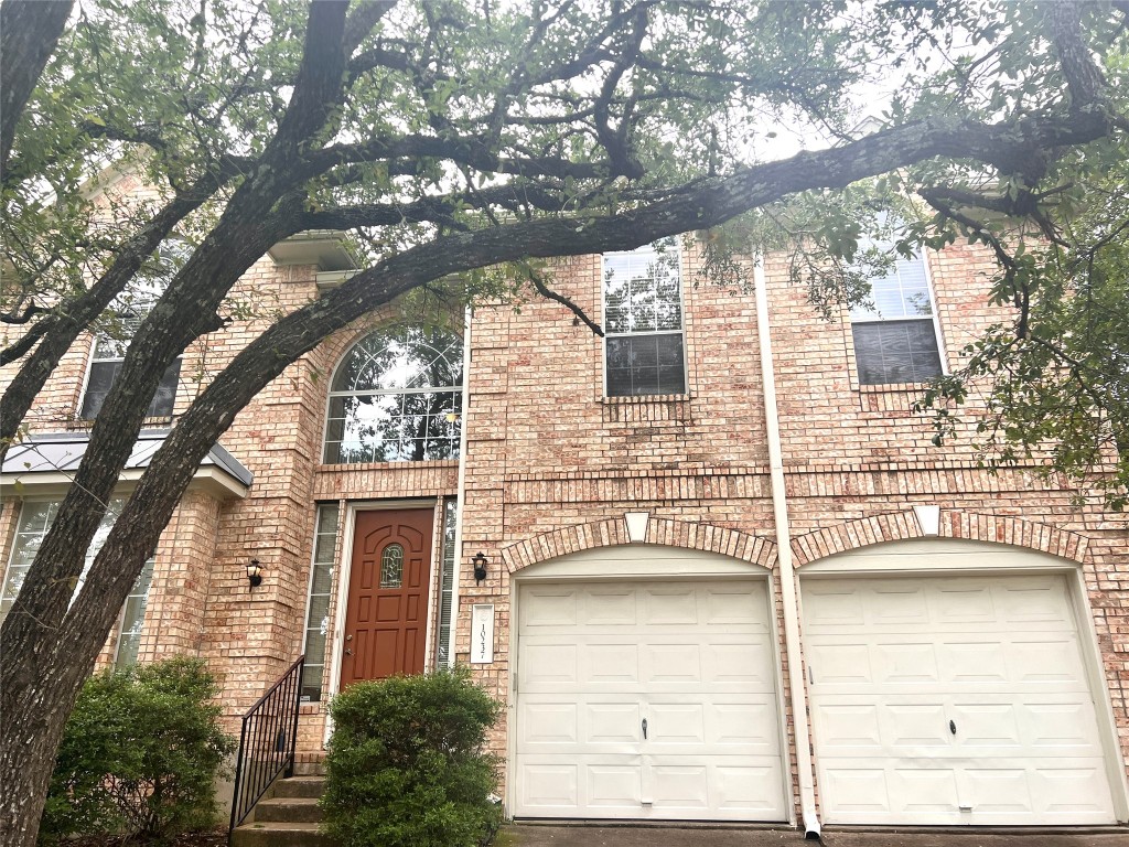 a front view of a house with a tree