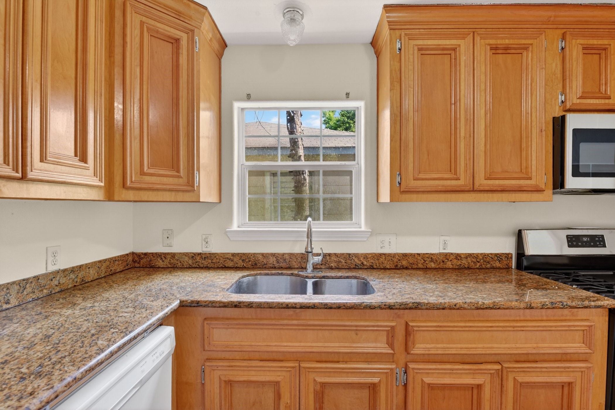 7013 St Augustine Street Houston, TX 77021 - Photo 10 of 35 a kitchen with granite countertop cabinets sink and window