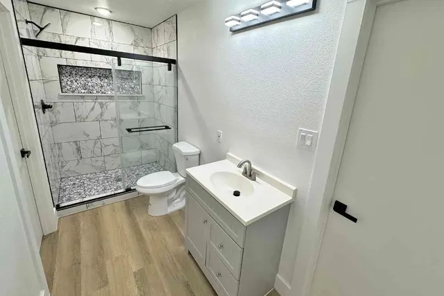 a bathroom with a sink a toilet and shower