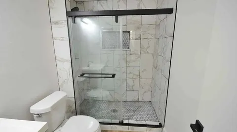 a bathroom with a toilet and a shower