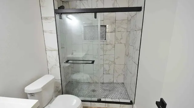 a bathroom with a toilet and a shower