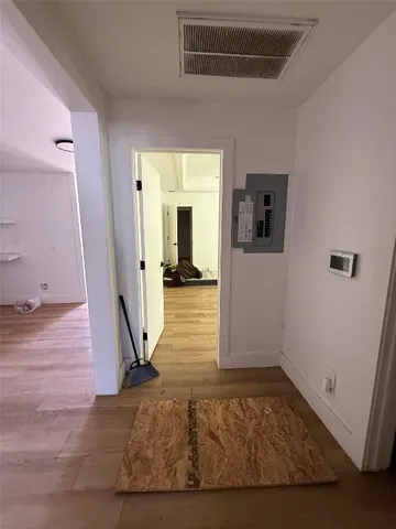 a view of a hallway with wooden floor and a living room