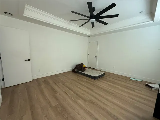 a view of room with a ceiling fan and wooden floor