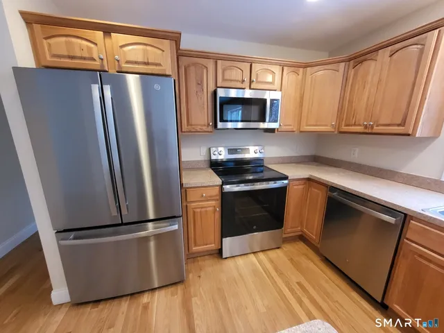 a kitchen with granite countertop white cabinets and stainless steel appliances