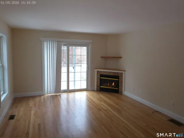 a view of an empty room with a window and fireplace
