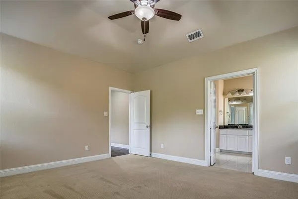 an empty room and chandelier fan