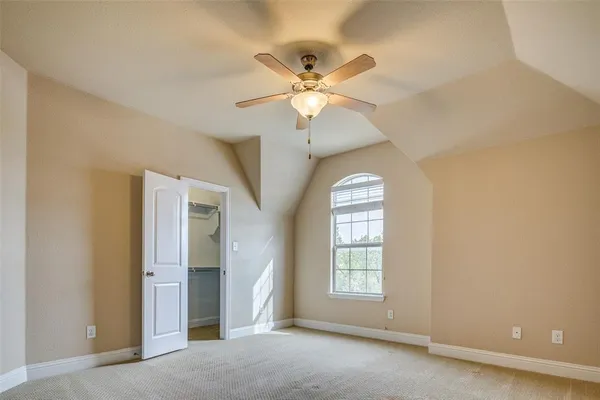 an empty room with a ceiling fan and a fan