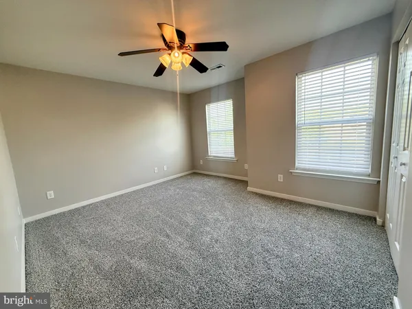 an empty room with a window and a fan